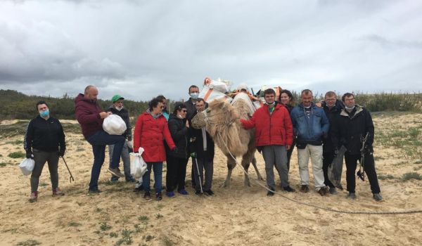 Photo de groupe avec l'ESAT lors d'une balade sur les plages landaises, dans un cadre de ramassage de déchets, l'une des actions écologiques de l'assocation Camel'idées de l'Atlantique